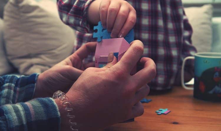 hand putting puzzle pieces into box