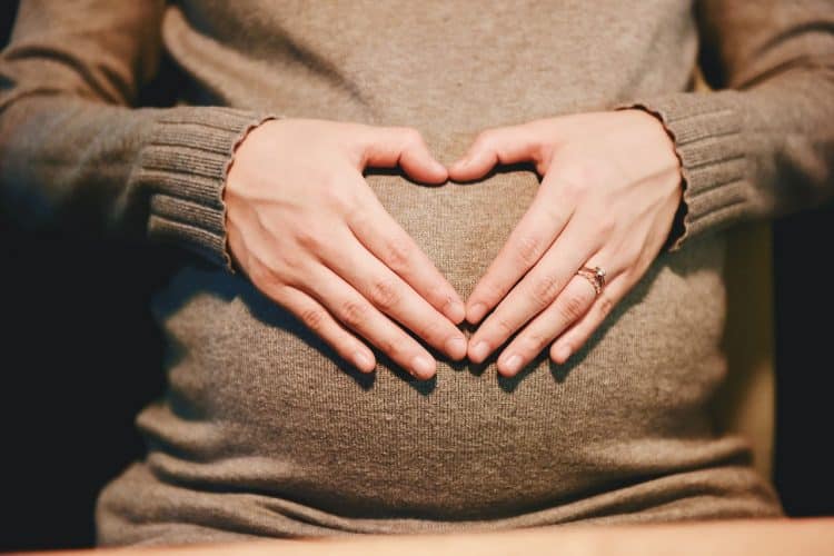Pregnant woman with hands on her stomach